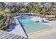 Aerial view of the zero depth community pool, with palm trees and deck chairs, surrounded by greenery at 4233 Lady Banks Ln, Ravenel, SC 29470