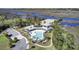 Aerial view of the community pool, with deck chairs, next to a river/wetlands at 4233 Lady Banks Ln, Ravenel, SC 29470