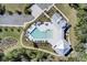 Aerial view of the community pool with deck chairs and buildings surrounded by lush green trees at 4233 Lady Banks Ln, Ravenel, SC 29470
