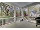 Covered porch with white railings, overlooking a landscaped yard, with a BBQ grill on the right side at 4233 Lady Banks Ln, Ravenel, SC 29470