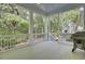 Covered porch with white railings, overlooking a landscaped yard, with a BBQ grill on the right side at 4233 Lady Banks Ln, Ravenel, SC 29470