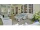 Bright sunroom with natural light from many windows, wicker furniture, ceiling fans, and views of a lush, wooded backyard at 4233 Lady Banks Ln, Ravenel, SC 29470