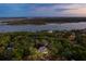 Twilight aerial view showcases a beautiful home surrounded by trees near a serene waterfront at 4291 Turtle Landing Ct, Johns Island, SC 29455