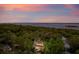 Elevated view of a beautifully illuminated home nestled within lush treetops with a tranquil waterfront backdrop at 4291 Turtle Landing Ct, Johns Island, SC 29455