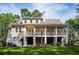 Back of house with covered porch, well-manicured lawn, and mature trees for added privacy at 4291 Turtle Landing Ct, Johns Island, SC 29455