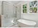 Modern bathroom with soaking tub and glass enclosed shower featuring white subway tile and natural light at 4291 Turtle Landing Ct, Johns Island, SC 29455
