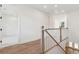 Bright hallway with hardwood floors and natural wood and white railings at 4291 Turtle Landing Ct, Johns Island, SC 29455