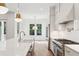 Well-lit kitchen featuring an island with a farmhouse sink, stainless steel appliances, and views to the exterior at 4291 Turtle Landing Ct, Johns Island, SC 29455