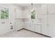 Well-lit laundry room featuring custom cabinets, stone countertops, and tile floors at 4291 Turtle Landing Ct, Johns Island, SC 29455