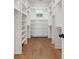Bright walk-in closet with built-in shelving and hardwood floors at 4291 Turtle Landing Ct, Johns Island, SC 29455