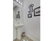 Stylish half-bathroom featuring a pedestal sink, decorative mirror, framed art, and modern fixtures at 4966 Hay Bale Ct, Summerville, SC 29485