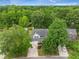 An aerial view of the home shows mature trees, blue shutters, a well-manicured lawn, and a driveway at 5406 Woodbreeze Dr, North Charleston, SC 29420