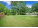 Spacious backyard with lush green lawn and mature trees providing shade at 5406 Woodbreeze Dr, North Charleston, SC 29420