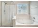 White bathroom features a soaking tub, glass shower, neutral decor and great natural light at 5406 Woodbreeze Dr, North Charleston, SC 29420