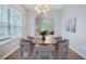 Contemporary dining room with an eye-catching chandelier and an arched entryway to a living space at 5406 Woodbreeze Dr, North Charleston, SC 29420