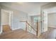 Upstairs hallway with wood floors, white banister and open doors at 5406 Woodbreeze Dr, North Charleston, SC 29420