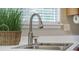 Close-up of a stainless steel kitchen sink with a modern faucet and view from the window at 5406 Woodbreeze Dr, North Charleston, SC 29420