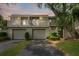 Inviting two-story condo with two garage doors, multiple decks, and lush green landscaping at 55 Fairway Dunes Ln # Week 2, Isle of Palms, SC 29451