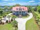 Stunning aerial view of grand home with manicured lawn, circular driveway, and river access at 5625 Crystal Harbor Ln, Hollywood, SC 29449
