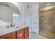 Bright bathroom featuring a wood vanity, decorative mirror, and glass door shower at 5625 Crystal Harbor Ln, Hollywood, SC 29449