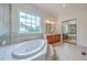 This bathroom features a soaking tub, a glass enclosed shower, and a vanity with a marble countertop at 5625 Crystal Harbor Ln, Hollywood, SC 29449