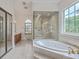 Bathroom featuring a glass-enclosed shower with decorative etching, a large soaking tub, and a vanity at 5625 Crystal Harbor Ln, Hollywood, SC 29449