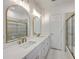Bathroom featuring dual sinks, marble countertop, framed mirrors, and modern lighting fixtures at 5625 Crystal Harbor Ln, Hollywood, SC 29449