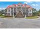Impressive home exterior with a grand staircase, red roof, and meticulously kept landscape at 5625 Crystal Harbor Ln, Hollywood, SC 29449