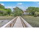 A long wooden private pier leads to a beautiful two-story traditional home with a red roof in a Lowcountry setting at 5625 Crystal Harbor Ln, Hollywood, SC 29449