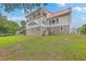 Stately home with a red roof and multiple decks, complemented by a lush green lawn and mature trees at 5625 Crystal Harbor Ln, Hollywood, SC 29449