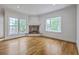 Bright living room with fireplace, hardwood floors, and large windows with picturesque views at 5625 Crystal Harbor Ln, Hollywood, SC 29449