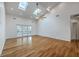Bright living room with hardwood floors, vaulted ceiling, skylights, and French doors to a deck at 5625 Crystal Harbor Ln, Hollywood, SC 29449