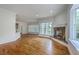 Inviting living room with hardwood floors, fireplace, and multiple windows offering natural light at 5625 Crystal Harbor Ln, Hollywood, SC 29449