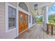 Inviting front porch with double doors, columns, and outdoor lighting at 5625 Crystal Harbor Ln, Hollywood, SC 29449