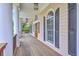Relaxing porch area with arched windows, wooden floors, and stately columns at 5625 Crystal Harbor Ln, Hollywood, SC 29449