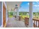 Expansive porch with wooden railings and elegant columns overlooking the lush landscape at 5625 Crystal Harbor Ln, Hollywood, SC 29449
