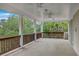 Expansive porch with stately columns, wooden railings, and ceiling fans for relaxing and entertaining outdoors at 5625 Crystal Harbor Ln, Hollywood, SC 29449