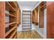 This walk-in closet has wooden floors and custom shelving and hanging storage for organization and style at 5625 Crystal Harbor Ln, Hollywood, SC 29449