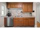 A well-lit kitchen with oak cabinets, stainless steel dishwasher, and granite counters at 672 W Oak Forest Dr, Charleston, SC 29407