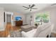 Cozy living room with hardwood floors, a modern ceiling fan, and large windows that allow ample natural light at 672 W Oak Forest Dr, Charleston, SC 29407