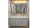 Bathroom featuring a double vanity with marble countertop, wooden mirror, and tile flooring at 9489 Sidneys Rd, Round O, SC 29474