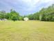 Expansive grassy yard surrounding a home, bordered by a wooden fence and mature trees at 9489 Sidneys Rd, Round O, SC 29474