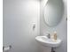 Clean powder room featuring a pedestal sink and round mirror at 9624 Scarborough Ct, Summerville, SC 29485