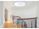 Grand staircase with decorative wrought iron, hardwood floors, and a skylight illuminating the elegant design at N Blvd, Mount Pleasant, SC 29464