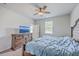 Bright bedroom with a ceiling fan, a large window, and an elegant dresser with a TV on top at 1003 Peridote Way, Ladson, SC 29456