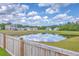 Picturesque view of community pond reflecting the sky and surrounding homes from the backyard at 1011 Peridote Way, Ladson, SC 29456