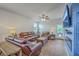 Cozy living room with a stylish blue accent wall, ceiling fan, and comfortable leather furniture at 1011 Peridote Way, Ladson, SC 29456