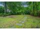 Lush backyard with stone pathway leading to seating beneath mature trees at 1035 Planters Curve, Mount Pleasant, SC 29464