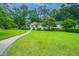 Charming home with a lush green lawn, walkway, and mature trees at 1035 Planters Curve, Mount Pleasant, SC 29464