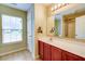 Well-lit bathroom vanity with neutral countertops, wood cabinets, and a large mirror with vanity lighting above at 1039 Steelechase Ln, Hanahan, SC 29410